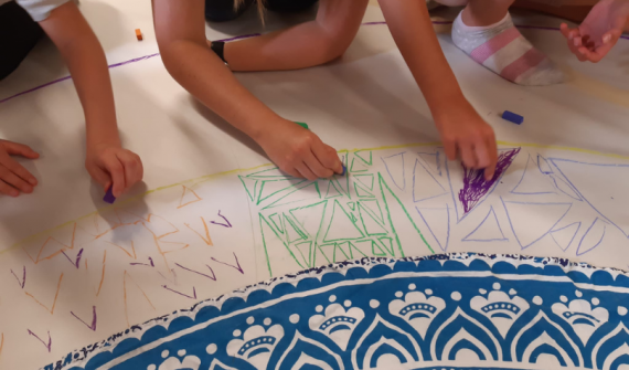 Creative workshop for families with SEND children on climate change featured image. Kids with their hands on a big white paper filled with artwork.