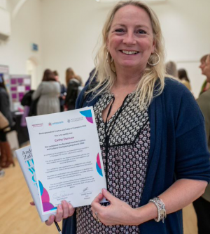 Blonde woman holding certificate